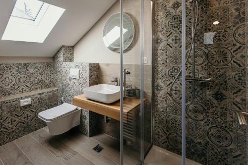 La salle de bains est pourvue d'un lavabo et d'une douche. dans l'établissement Pansion "Fawlty Towers" Sarajevo, à Sarajevo