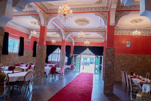 廷吉爾的住宿－HOTEL LA VALLEE DES KASBAHS CHEZ ILYAS，餐厅拥有红色的墙壁和桌椅