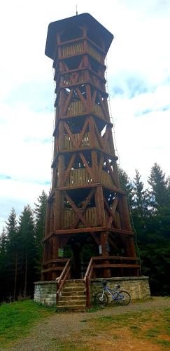 a bike parked in front of a wooden tower at Penzion U Bečvy in Karolinka
