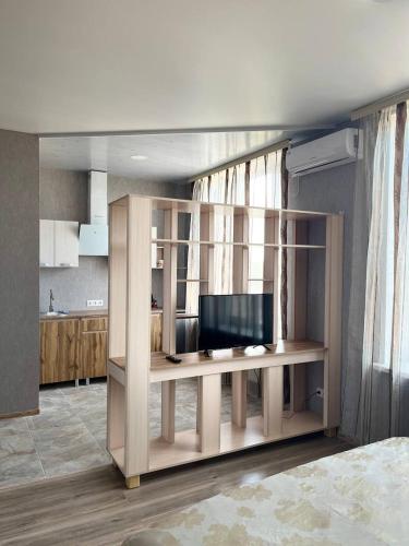 a living room with a desk with a flat screen tv at Отель Меридиан in Zolotonosha