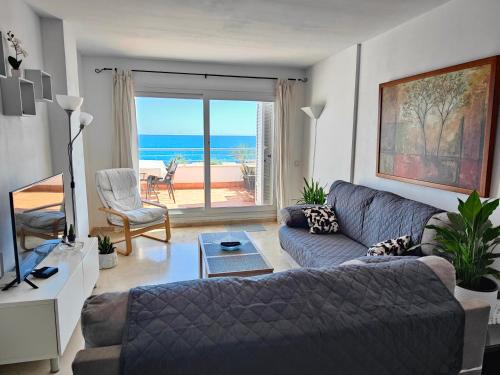 sala de estar con sofá y vistas al océano en Apartamento Playa del Faro, en Garrucha