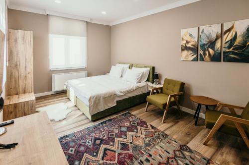 a bedroom with a bed and a table and a chair at Pansion "Fawlty Towers" Sarajevo in Sarajevo
