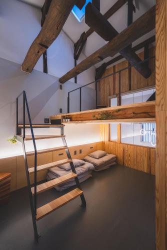 a bunk bed room with bunk beds and a staircase at ゲストハウス　遊楽２F in Osaka