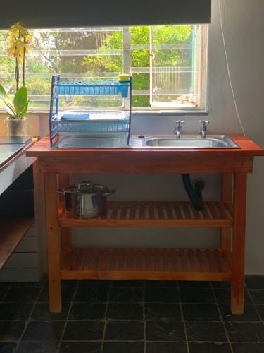 um lavatório de madeira numa cozinha com uma janela em The Vine Cottage at Viva Connect em Cullinan