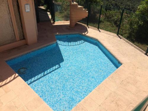 uma piscina com água azul num quintal em Magnifique appartement vue mer la turbie em La Turbie