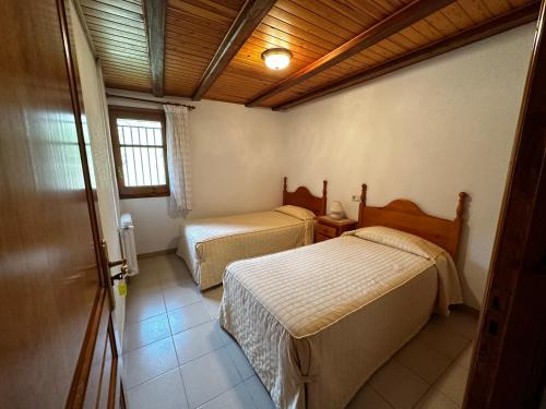 1 dormitorio con 2 camas en una habitación con ventana en Apartament Casa Sastre, en Espot