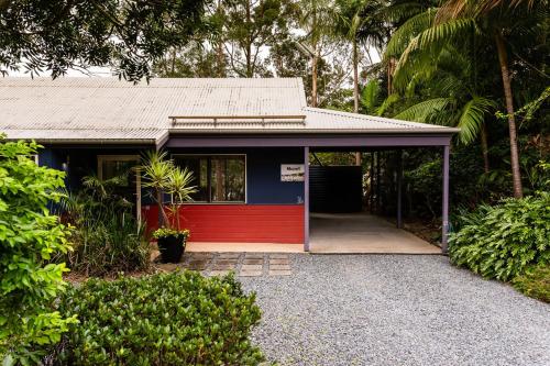 a small house with a red and blue door at Lake Russell Lakeside Retreat in Emerald Beach