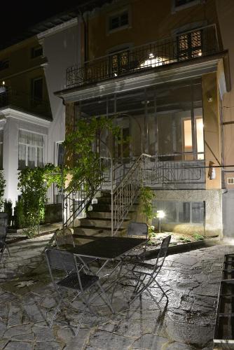 a table and chairs in front of a building at night at Residenza Cece' in Lecco