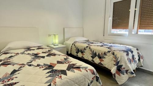 una camera da letto con due letti e una finestra di Riells de Mar A1 a L'Escala