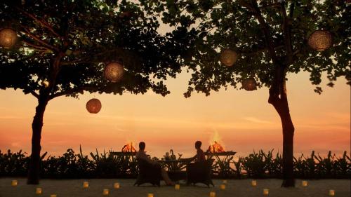 Due persone sedute a un tavolo a guardare il tramonto di Holiday Inn Express Hotel & Suites McAlester, an IHG Hotel a McAlester