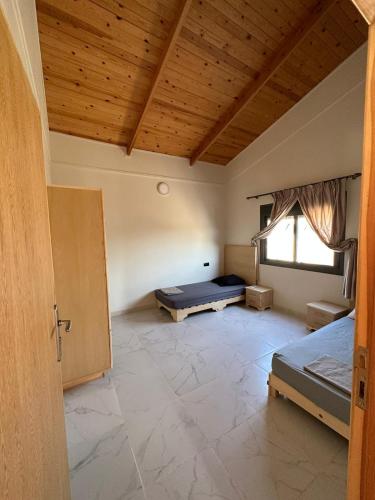 pusty pokój z dwoma łóżkami i oknem w obiekcie Villa Clémentine piscine privée - 6 pers w mieście Berkane