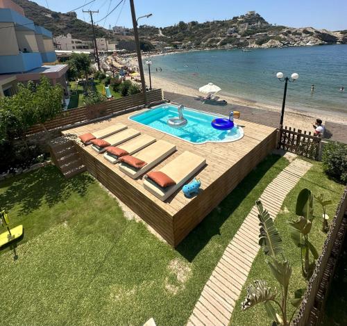 a swimming pool with lounge chairs next to a beach at Beach front apartment with swimming pool in Ligaria