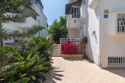 an alley between two buildings with plants and flowers at Luxury Villa 6BR with Swimming Pool by Beach - Villa Costa in Rishon LeẔiyyon