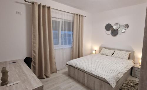 ein weißes Schlafzimmer mit einem Bett und einem Fenster in der Unterkunft Mosnita Nouă CrisApart04 in Moşniţa Veche