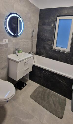 a bathroom with a sink and a toilet and a mirror at Moșnița CrisApart04 - factura PJ in Moşniţa Veche