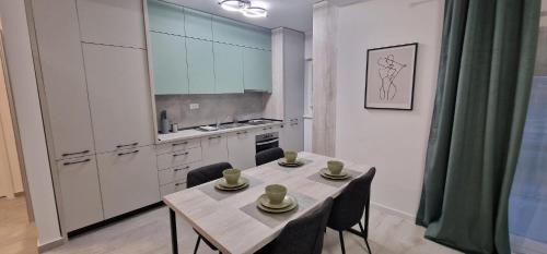 a kitchen with a table and two chairs and a kitchen with a table and chairs at CrisApart04 in Moşniţa Veche