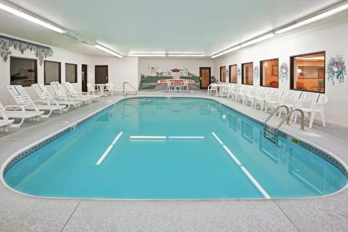 a large swimming pool with chairs and a table at Holiday Inn Express & Suites Alliance, an IHG Hotel in Alliance