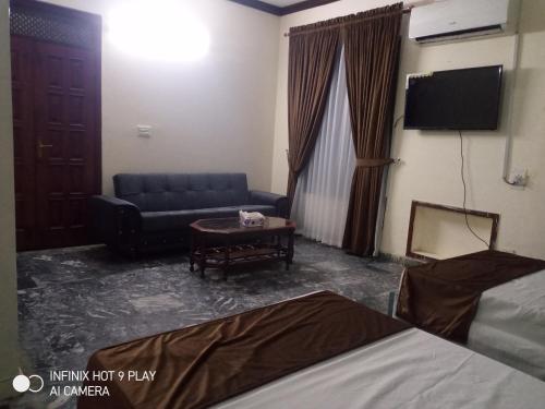 ein Wohnzimmer mit einem Sofa und einem Tisch in der Unterkunft Noor INN Guest House in Lahore