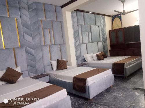 Zimmer mit 2 Betten und einer Wand mit 2 Betten in der Unterkunft Noor INN Guest House in Lahore