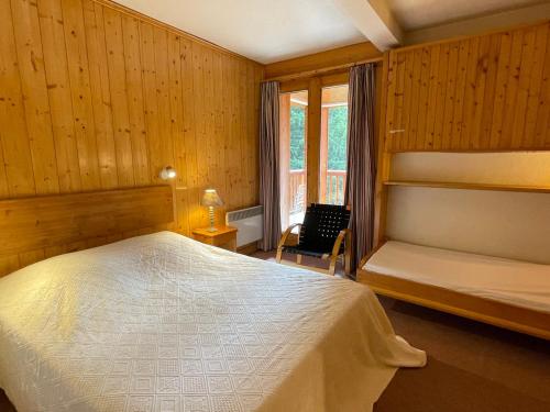 une chambre avec un lit, une chaise et une fenêtre dans l'établissement Appartement 2 pièces à Meribel, proche piste et commerces, avec parking et casier à ski - FR-1-411-717, à Les Allues