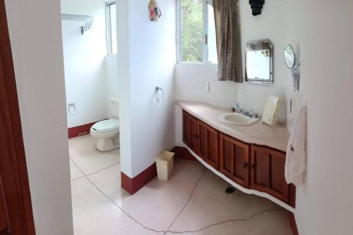 a bathroom with a sink and a toilet and a window at La siempre bella Tamiahua in Tamiahua