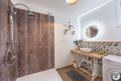 a bathroom with a shower with a wooden wall at Gîte du P'tit Colibri in Gury