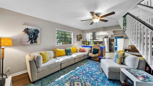 a living room with a couch and a ceiling fan at Zen Jungle House by Busch Gardens Sleeps 10 with Outdoor Games and bikes! in Tampa