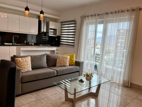 a living room with a couch and a glass table at SOHA SUITES II in Santiago de los Caballeros