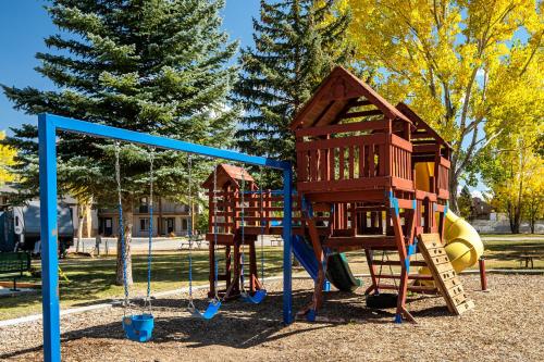un parque infantil con 2 columpios y un tobogán en Sun Outdoors Garden City Utah en Garden City