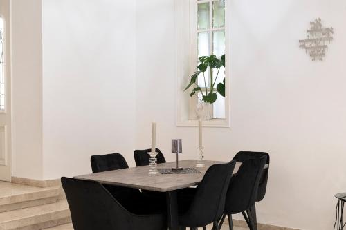 a dining room with a table and black chairs at Luxury Villa 6BR with Swimming Pool by Beach - Villa Costa in Rishon LeẔiyyon