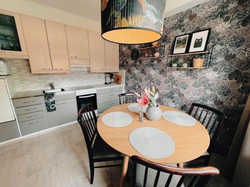 cocina con mesa de madera y sillas en una habitación en Pieni lomahuoneisto ja ulkoporeallas, en Mynämäki