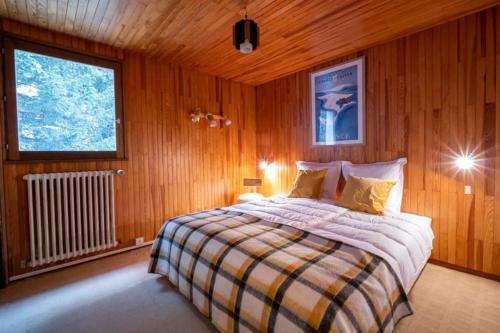 a bedroom with a bed in a wooden wall at Chalet des Écureuils - Grand chalet familial proche des pistes avec parking in Courchevel