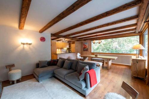 un salon avec un canapé et une table dans l'établissement Chalet des Écureuils - Grand chalet familial proche des pistes avec parking, à Courchevel