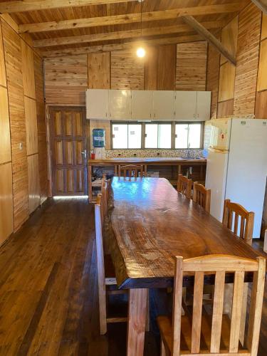 uma cozinha com uma grande mesa de madeira e cadeiras em str_on 2 em Encarnación