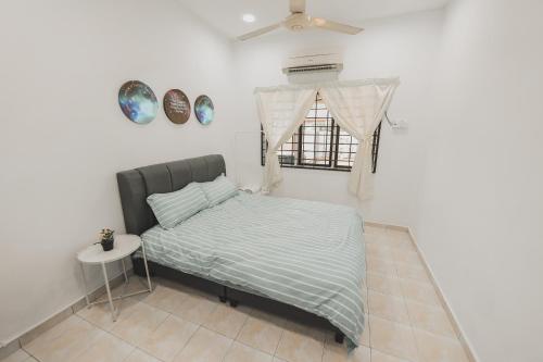 a bedroom with a bed and a window and a table at PD Corner Lot 5R3BR 15pax Pool Homestay 5min to Beach in Port Dickson