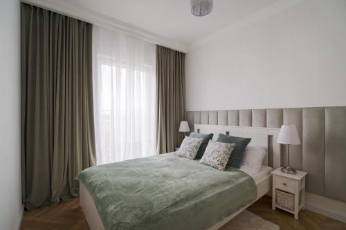 ein weißes Schlafzimmer mit einem Bett und einem Fenster in der Unterkunft La Boutique Verte in Warschau