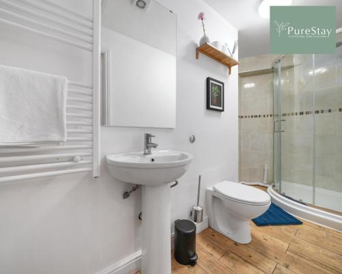 a white bathroom with a toilet and a sink at Stunning Two Bed Apartment By PureStay Short Lets & Serviced Accommodation Leamington With Free WiFi in Leamington Spa