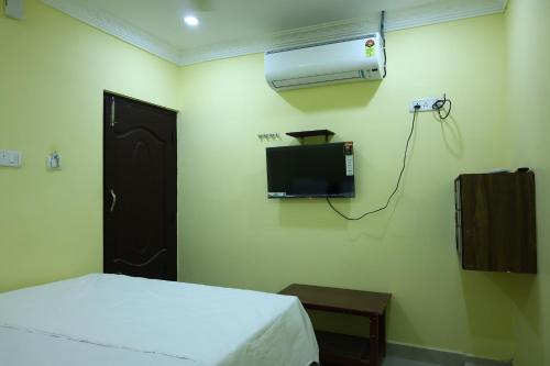 a bedroom with a bed and a air conditioner on the wall at MSN Residency in Srikalahasti