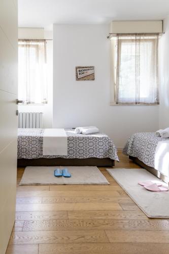 a bedroom with two beds and two rugs on the floor at Ca'Rosa Venezia in Venice