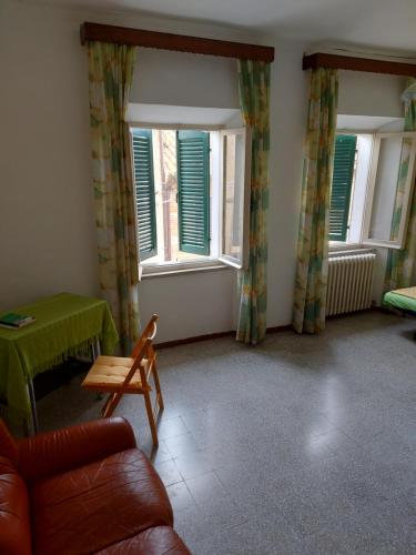 a living room with a couch and two windows at Casa nel centro storico a Loreto, 2 km dal mare in Loreto