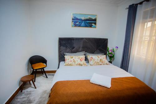 ein Schlafzimmer mit einem großen Bett und einem Stuhl in der Unterkunft MANDJ STAYS in Seeta