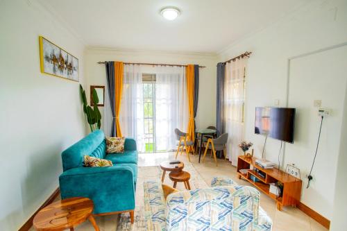 ein Wohnzimmer mit einem blauen Sofa und einem TV in der Unterkunft MANDJ STAYS in Seeta