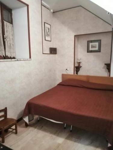1 dormitorio con 1 cama grande y 1 silla en casetta a Pescasseroli le 4 stagioni, en Pescasseroli