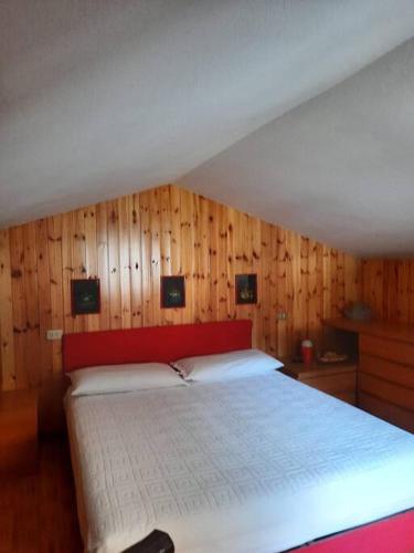 a bedroom with a large bed with wooden walls at Mansarda Carona in Carona