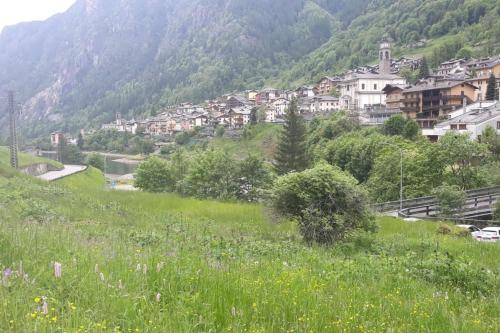 a green hillside with a village in the distance at Mansarda Carona in Carona
