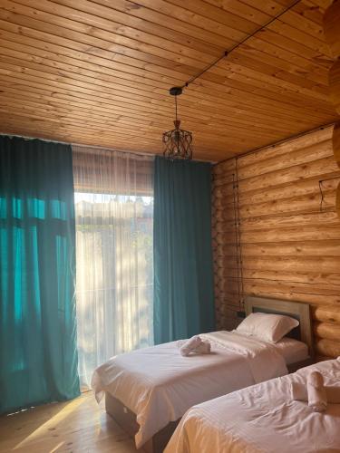 een slaapkamer met 2 bedden en een raam bij Hotel ANNA PALACE in Khulo