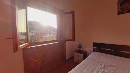 a bedroom with a bed and a large window at Casa PERLA panoramica 300m dal centro in Tagliacozzo