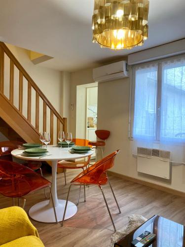 une salle à manger avec une table, des chaises et un lustre dans l'établissement Le Duplex d'Austin Power, à Orléans
