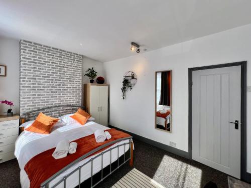 a bedroom with a bed and a brick wall at Clarence House 3 Bedrooms 8min to Station E17 North East London in London