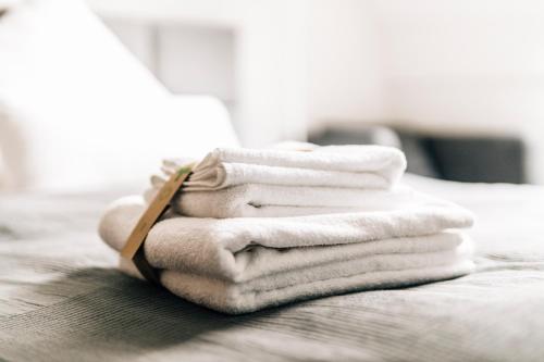 una pila de toallas sentadas encima de una cama en Stadt-Appartement CityLife en Bielefeld